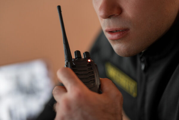 Portrait of male security guard with radio station and camera screens