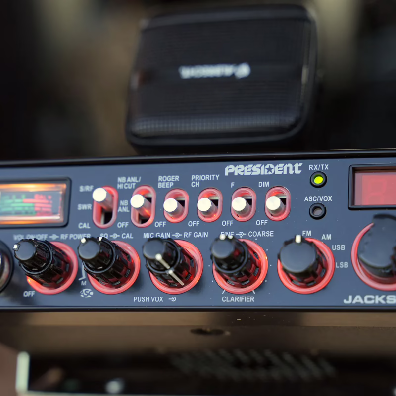 Close-up of a President Jackson II CB radio with illuminated controls, display screen, and microphone, ideal for radio communication content.